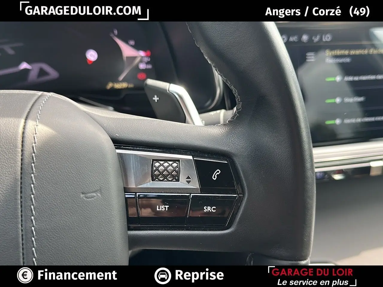 Gros plan sur les commandes au volant en cuir noir du DS7 7 BlueHDi 130 EAT8 Rivoli, avec écran numérique en arrière-plan.