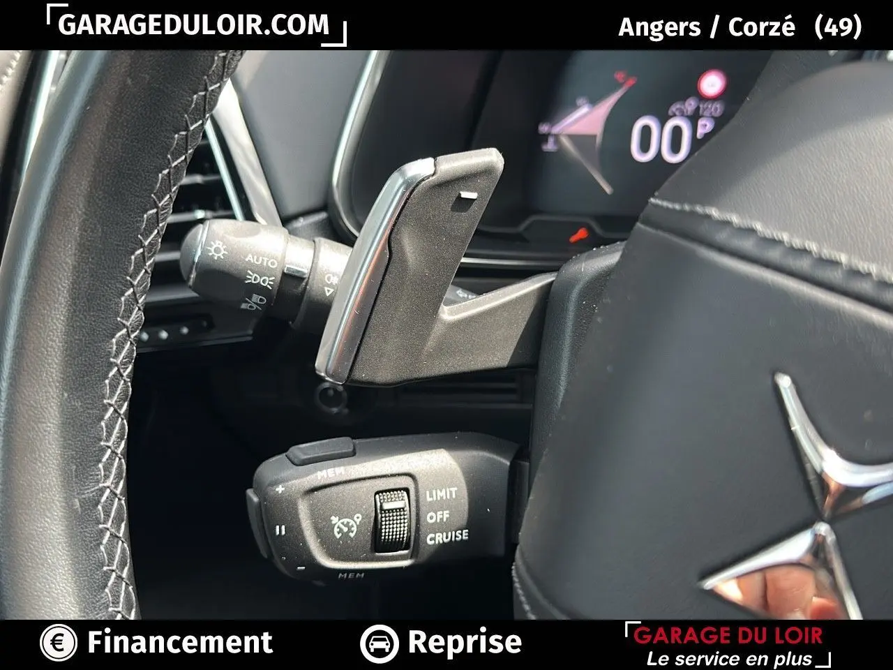 Gros plan sur les commandes au volant en cuir noir du DS7 7 BlueHDi 130 EAT8 Rivoli, affichage numérique en arrière-plan.