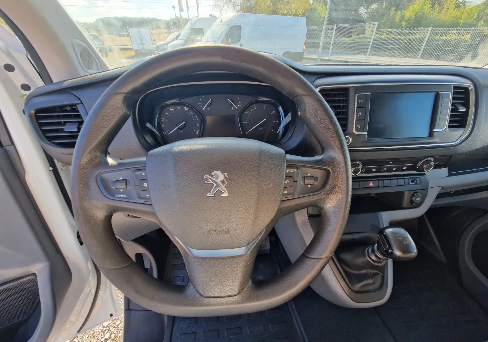 Vue intérieure centrée sur le volant Peugeot d'un Expert Fourgon blanc 2020 avec tableau de bord et levier de vitesses manuel.