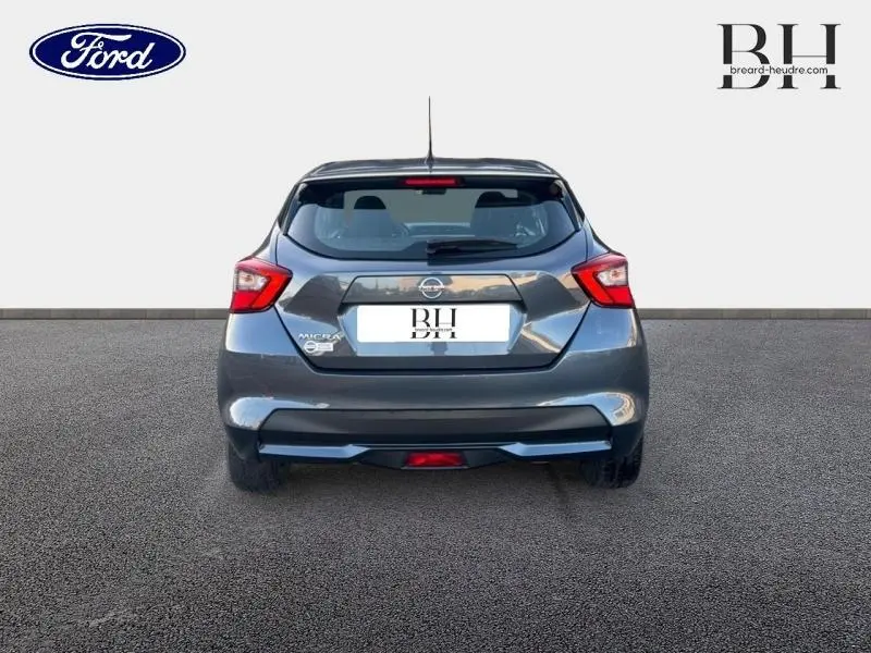 Vue arrière d'une Nissan Micra gris acier 2018 avec becquet et feux arrière distinctifs allumés.