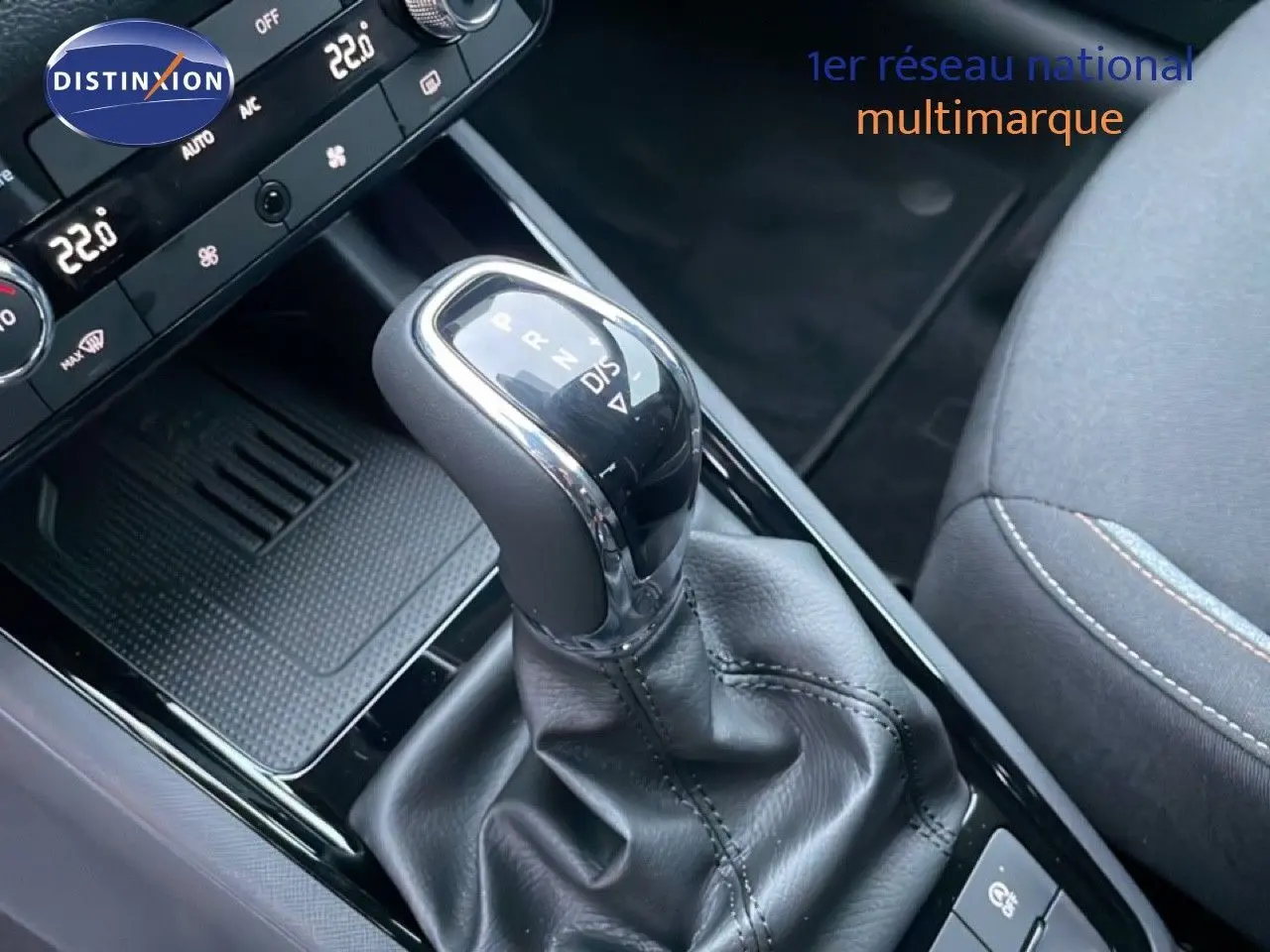 Gros plan sur la commande de boîte automatique du Skoda Kamiq gris graphite, avec console et siège tissu visibles.