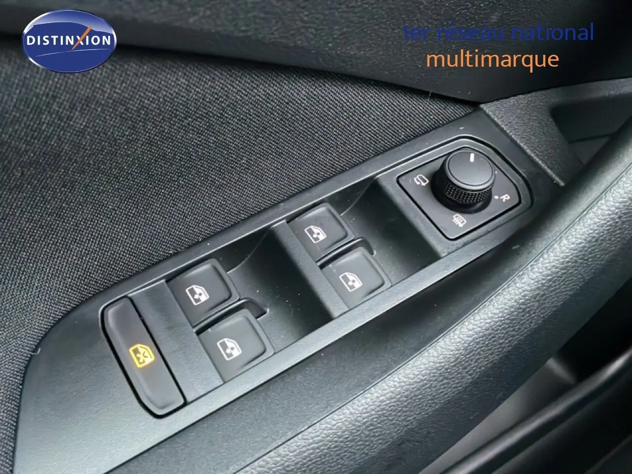 Gros plan sur les commandes de lève-vitres et réglage des rétroviseurs côté conducteur d’un Skoda Kamiq gris graphite.