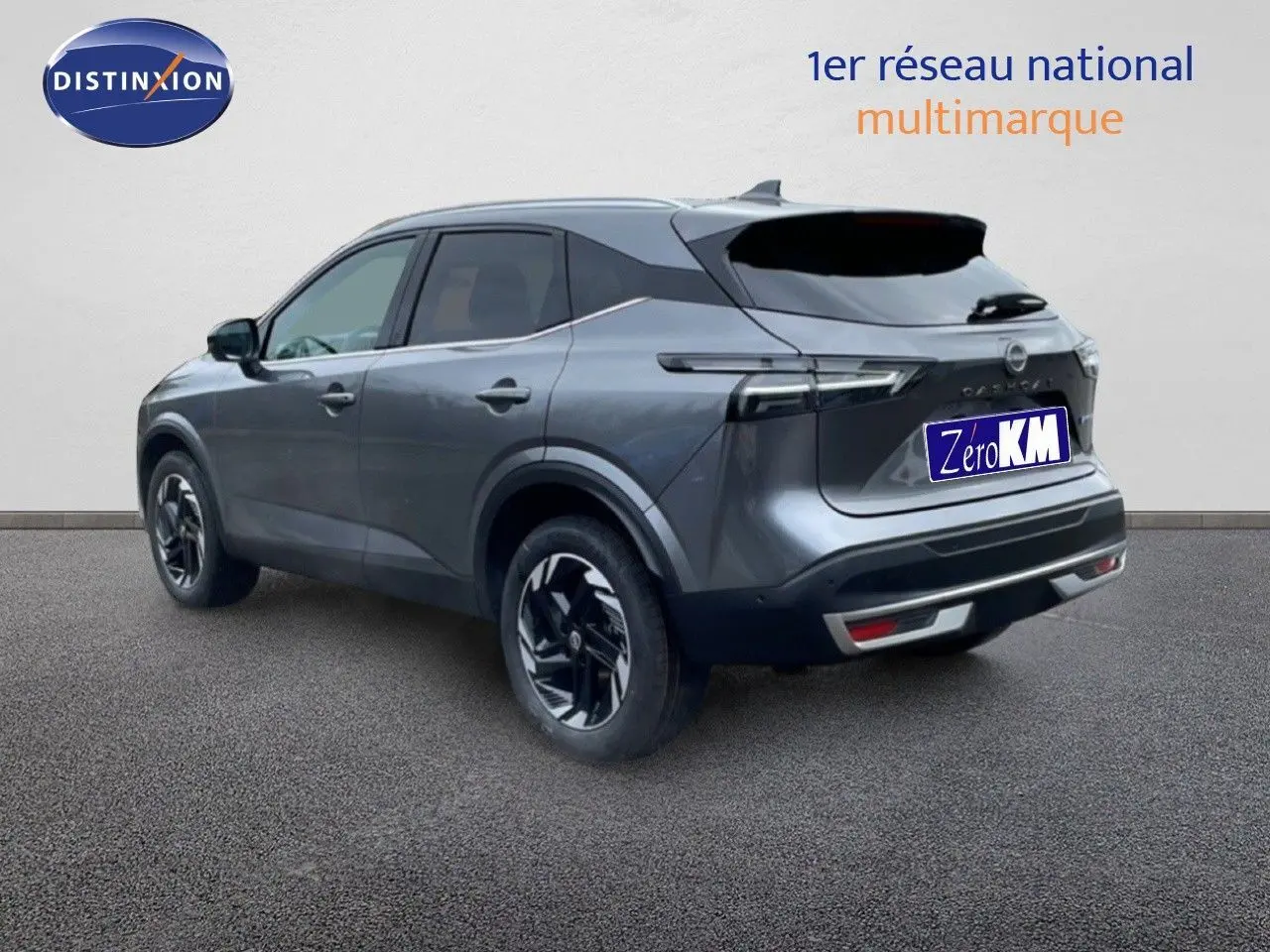 Vue 3/4 arrière du Nissan Qashqai 2025 gris squale métal avec jantes noires et toit foncé contrasté.