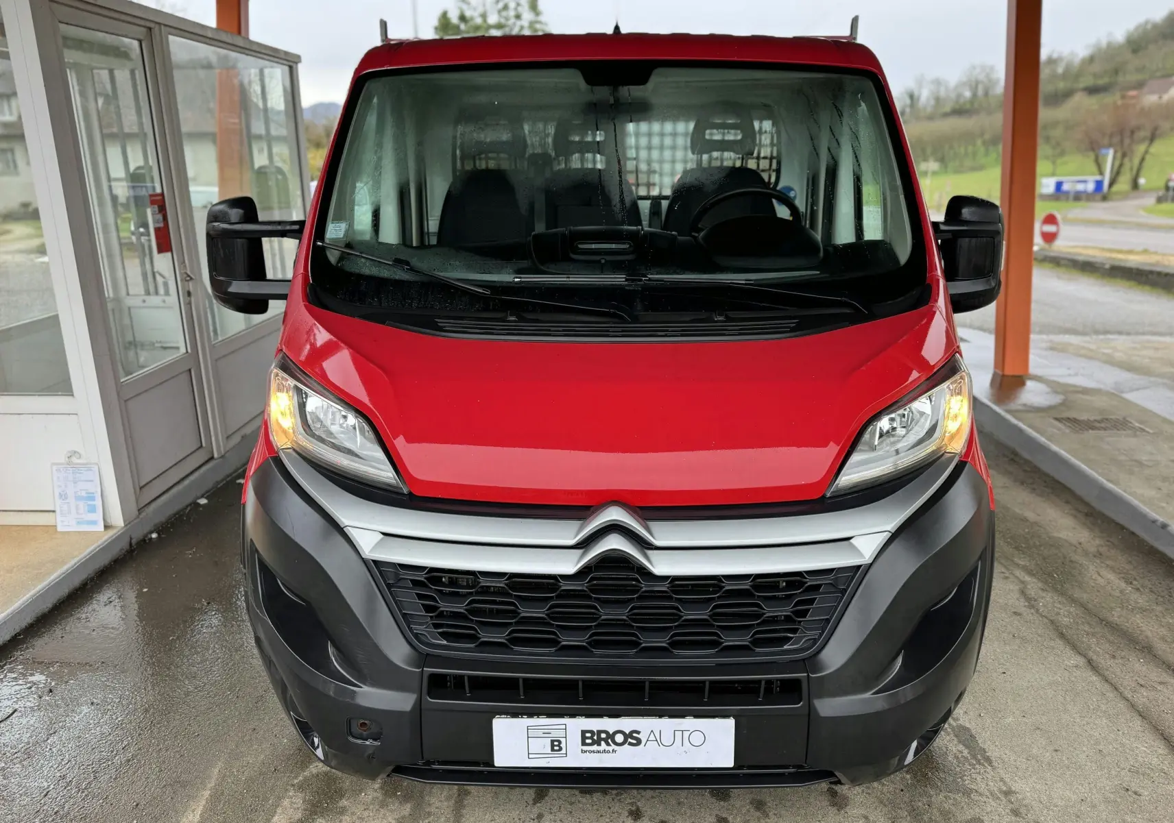 Vue frontale d'un Citroën Jumper benne rouge de 2019 avec feux allumés et calandre noire distinctive.