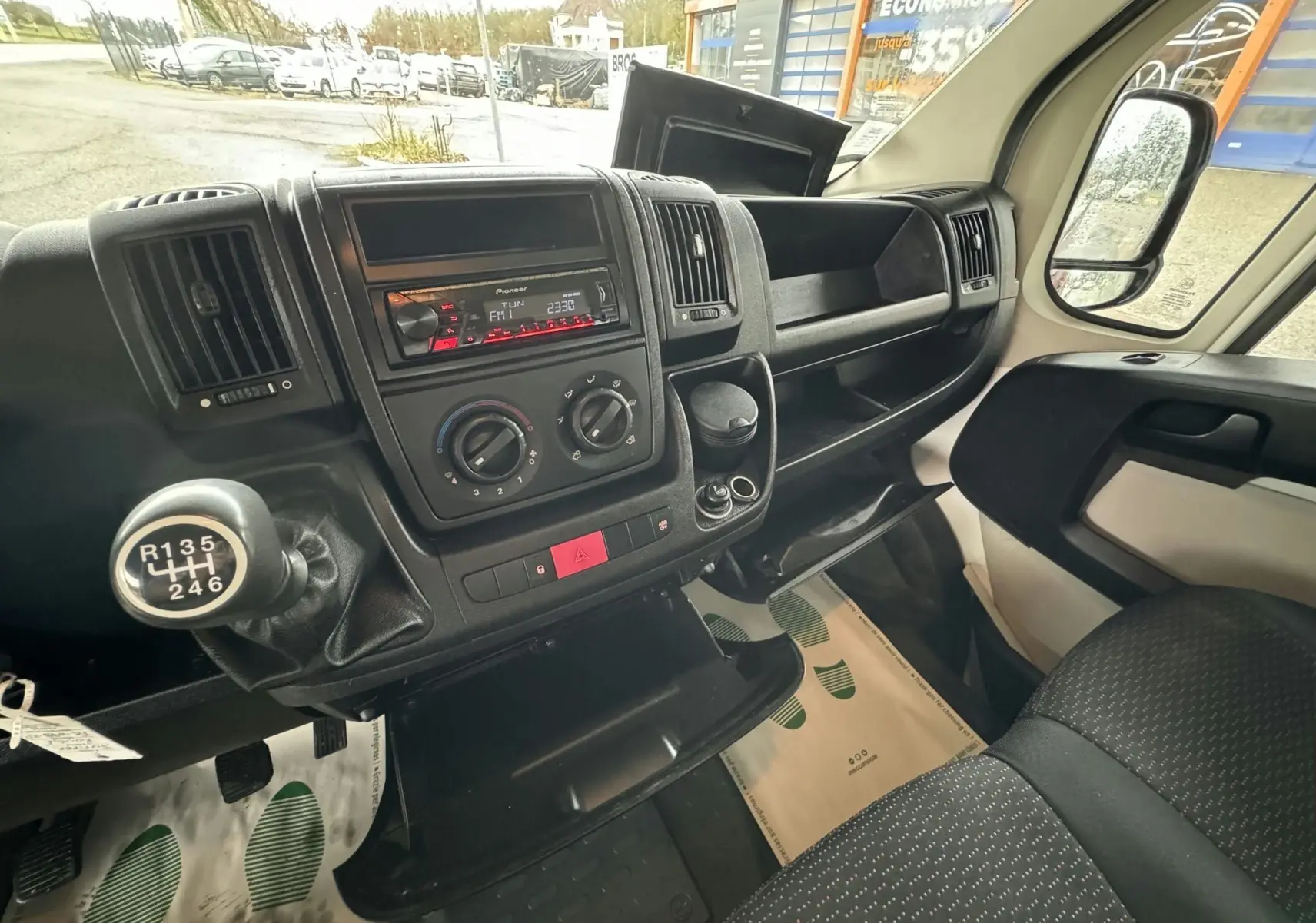 Intérieur du Citroën Jumper rouge 2019, vue côté passager sur tableau de bord et levier de vitesses manuel.