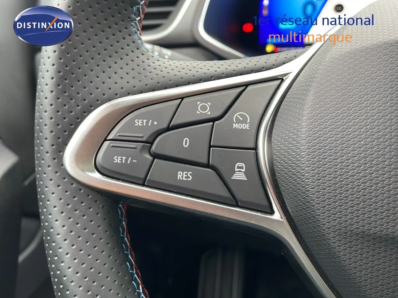 Gros plan sur les commandes au volant en cuir perforé noir du Renault Symbioz gris Rafale, version hybride 2025.