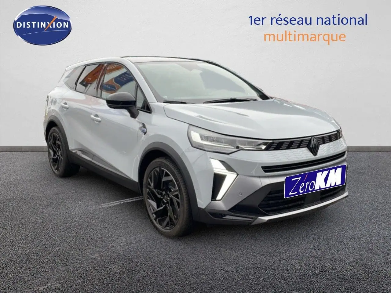 Renault Symbioz E-Tech gris Rafale métal, vue 3/4 avant droit avec jantes noires et signature lumineuse LED.