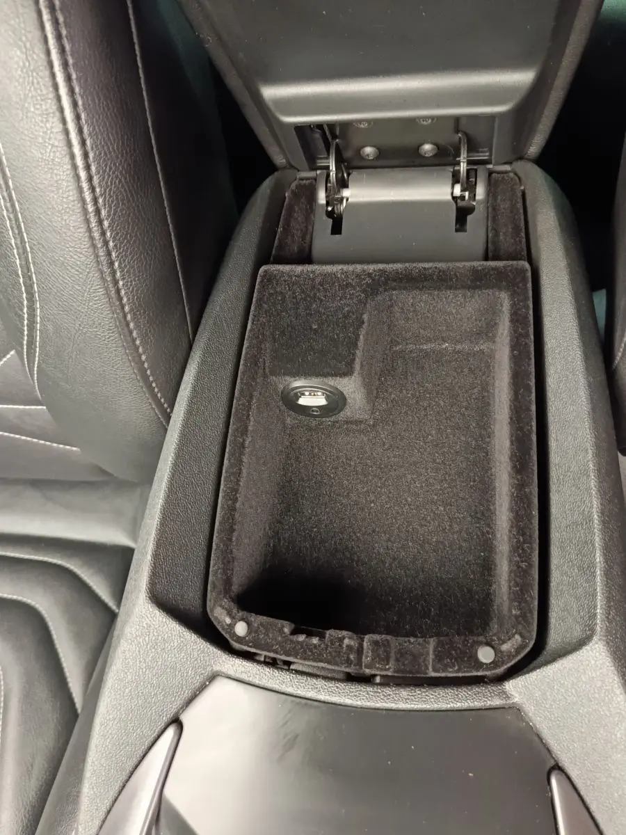 Vue rapprochée de l'accoudoir central ouvert en tissu noir dans une DS5 2018, avec prise USB visible.