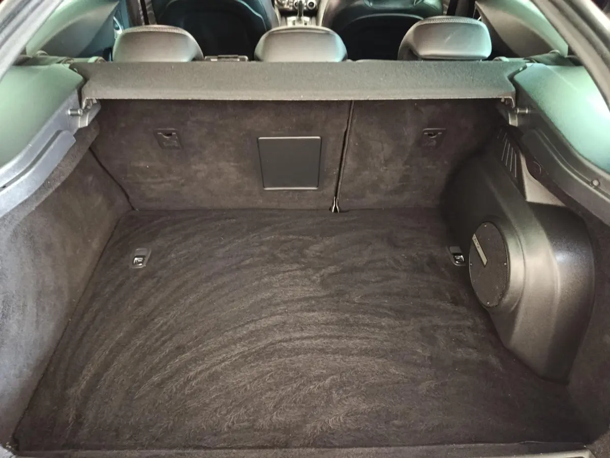 Coffre spacieux noir du DS5 BlueHDi 180 vu de l'intérieur arrière, avec banquette arrière et enceinte intégrée visible.