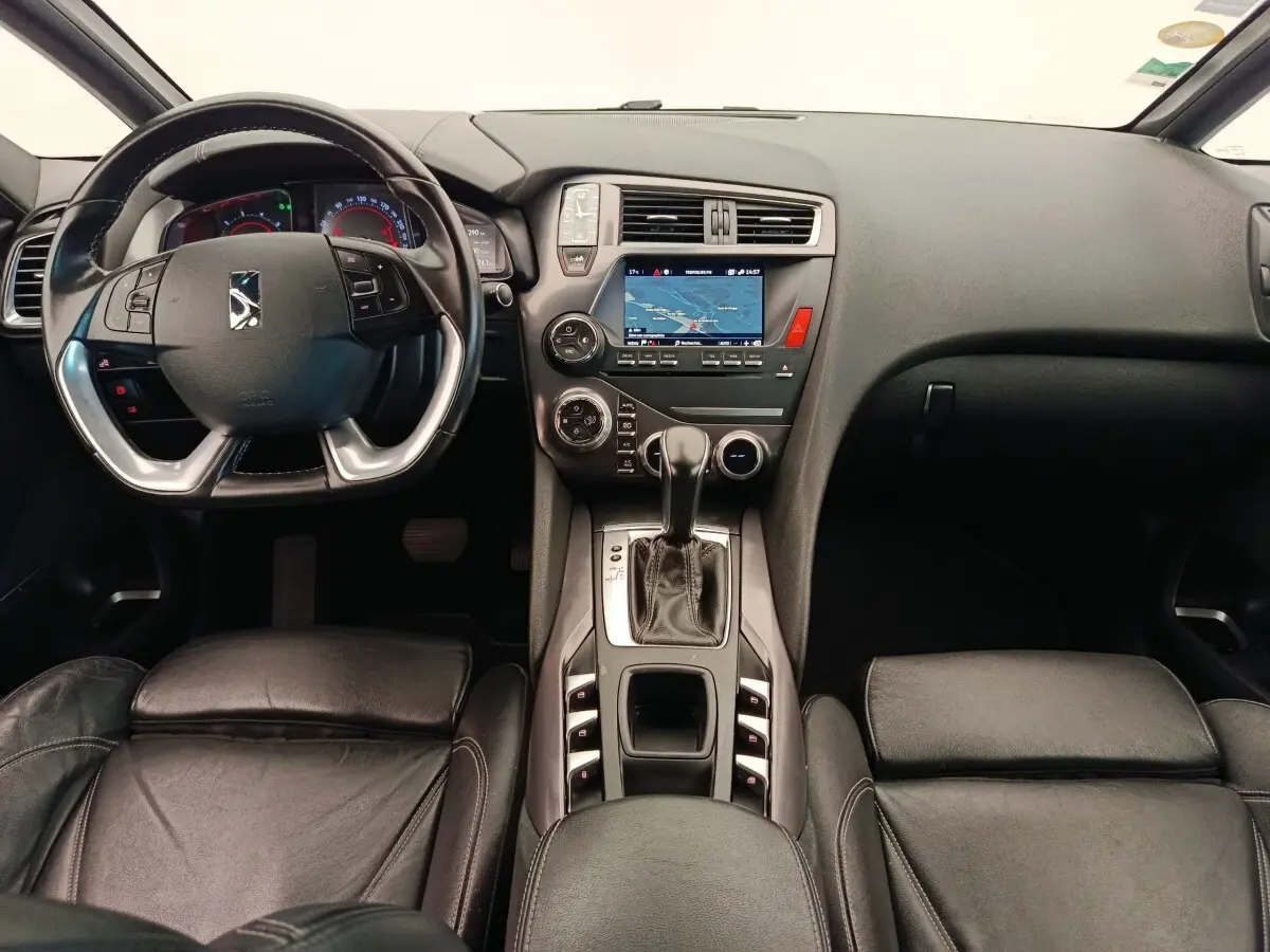 Vue intérieure avant du tableau de bord et console centrale noire du DS5 BlueHDi 180 Automatique Chic avec écran tactile de navigation.