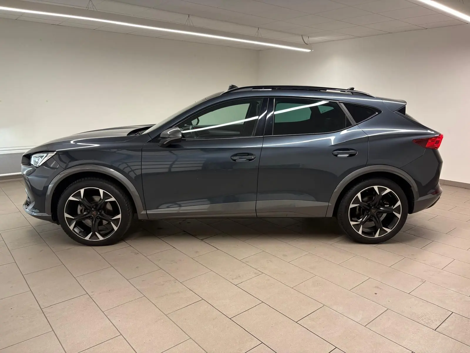 Vue de profil côté gauche du CUPRA Formentor 1.5 TSI 150 DSG7 VZ-LINE 2023 en gris magnétique avec jantes noires.