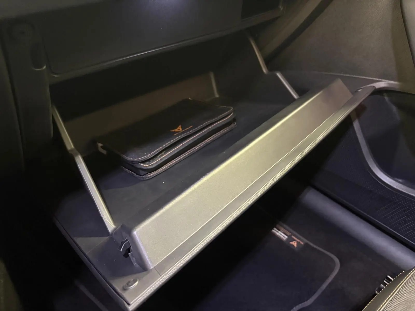 Vue rapprochée de la boîte à gants ouverte du CUPRA Formentor 1.5 TSI 150 DSG7 VZ-LINE 2023 avec pochette noire à l'intérieur.