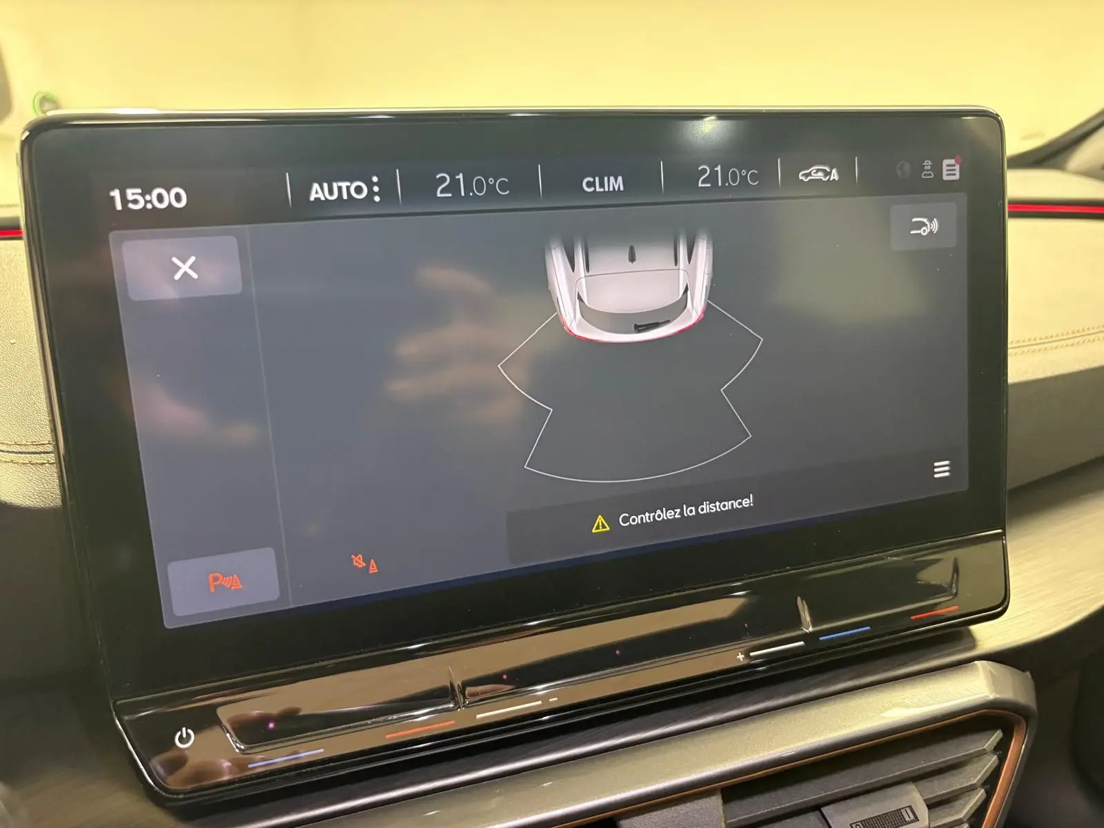 Écran tactile central du tableau de bord du CUPRA Formentor 2023 affichant l'aide au stationnement et la climatisation à 21°C.