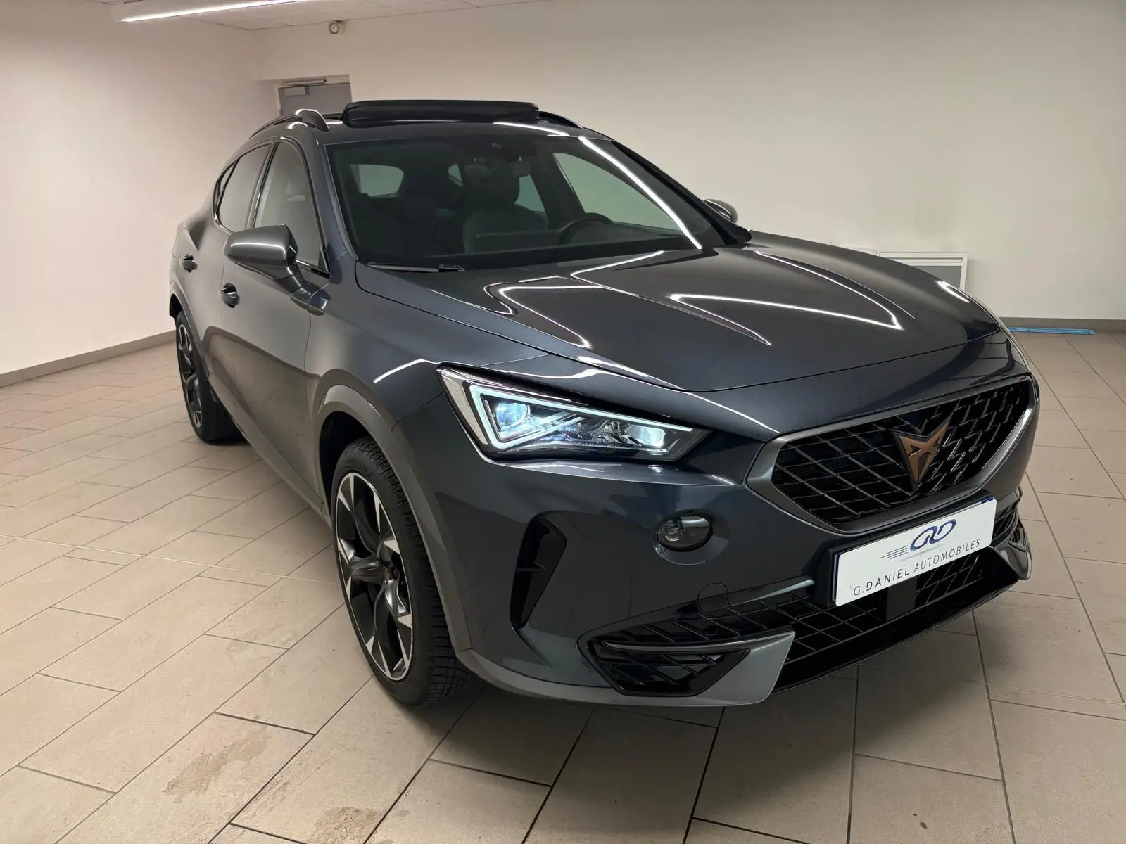 Vue 3/4 avant du CUPRA Formentor gris magnétique 2023 avec calandre noire et jantes alliage distinctives.