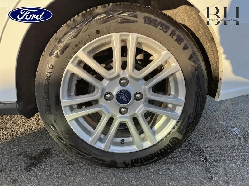 Gros plan sur la jante alu 16 pouces et pneu Continental du côté arrière droit d’un Ford Tourneo Courier blanc Glacier.