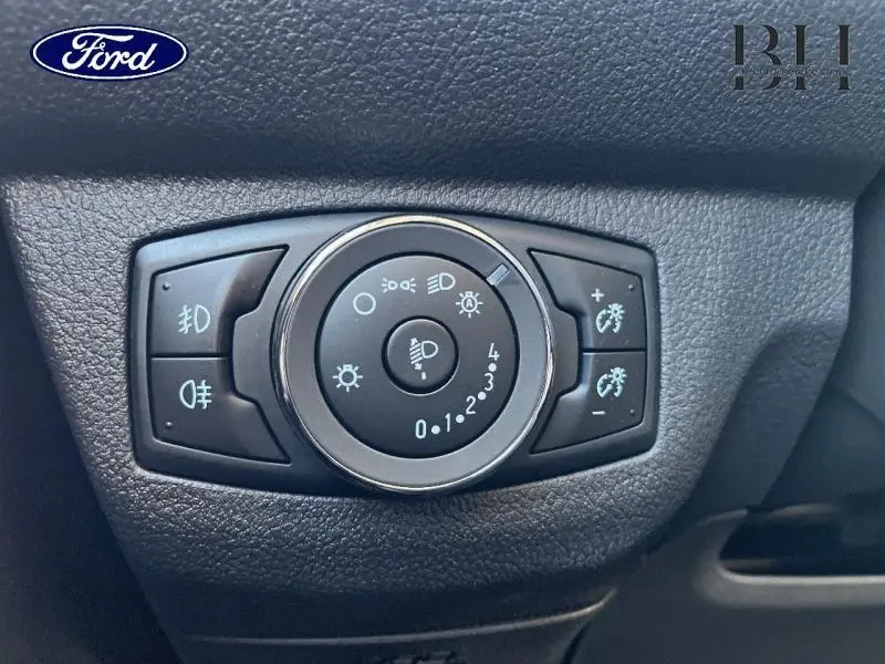 Gros plan sur le bouton de réglage des phares du Ford Tourneo Courier 2022, intérieur noir texturé.