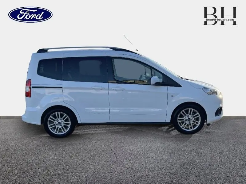 Profil droit du Ford Tourneo Courier blanc glacier 2022 avec portes coulissantes et jantes alliage visibles.