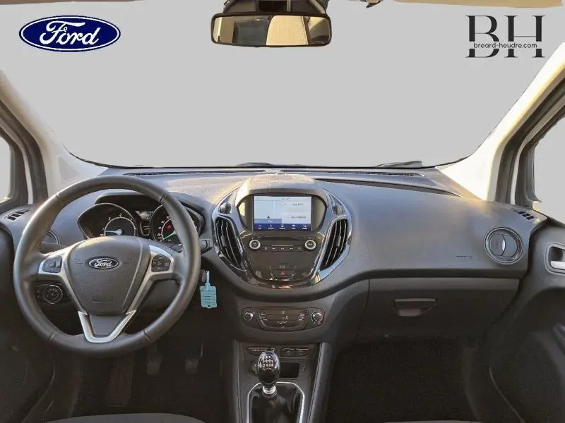 Vue intérieure avant du Ford Tourneo Courier 2022 avec tableau de bord noir et écran tactile central.