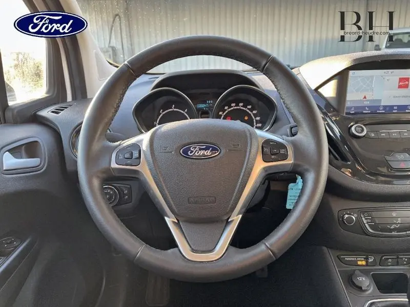 Vue frontale du volant cuir noir du Ford Tourneo Courier 2022 avec tableau de bord et écran tactile GPS Sync3.