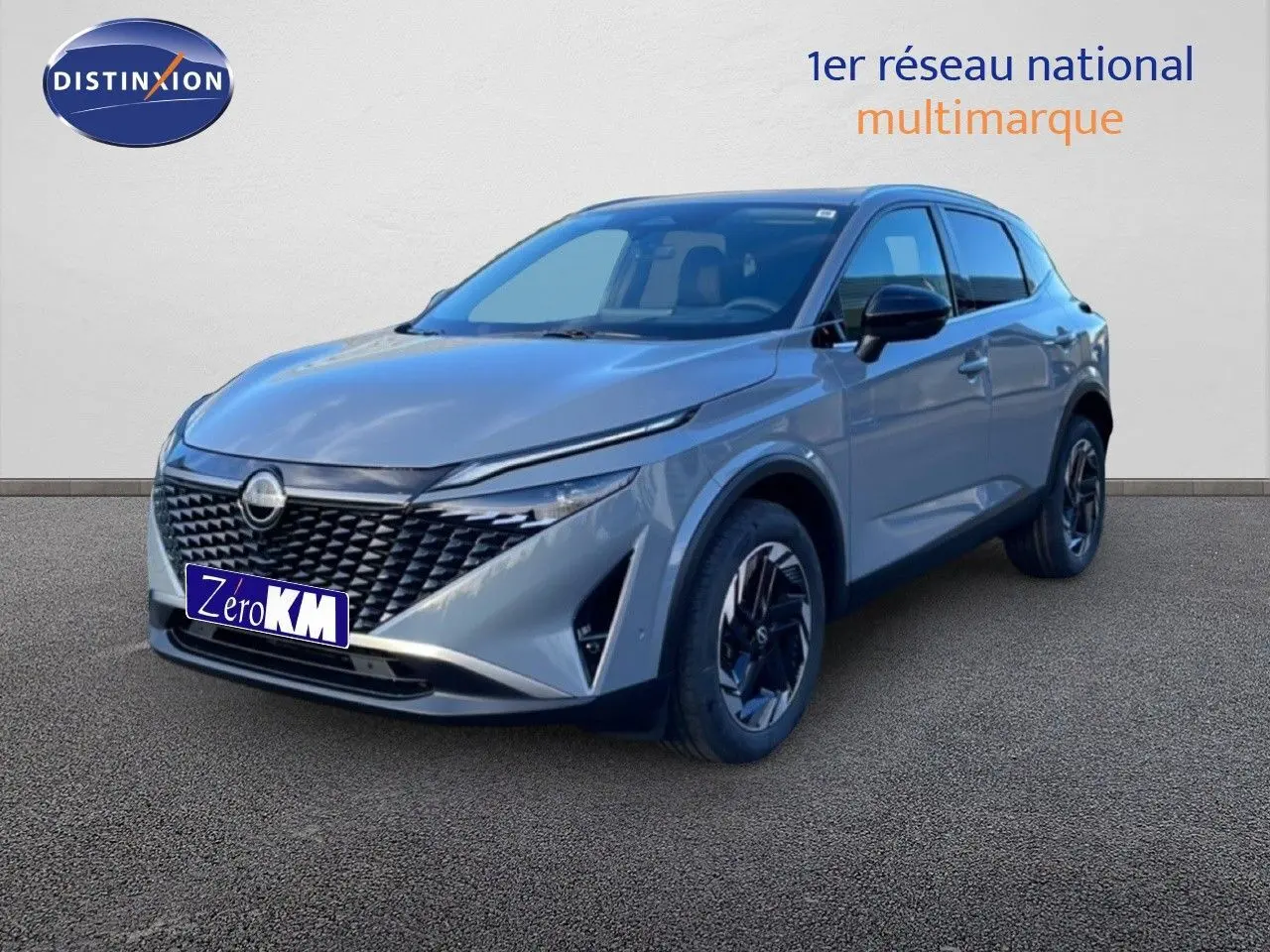 Vue 3/4 avant du Nissan Qashqai 1.5 E-POWER gris argile métal avec calandre noire et jantes noires.
