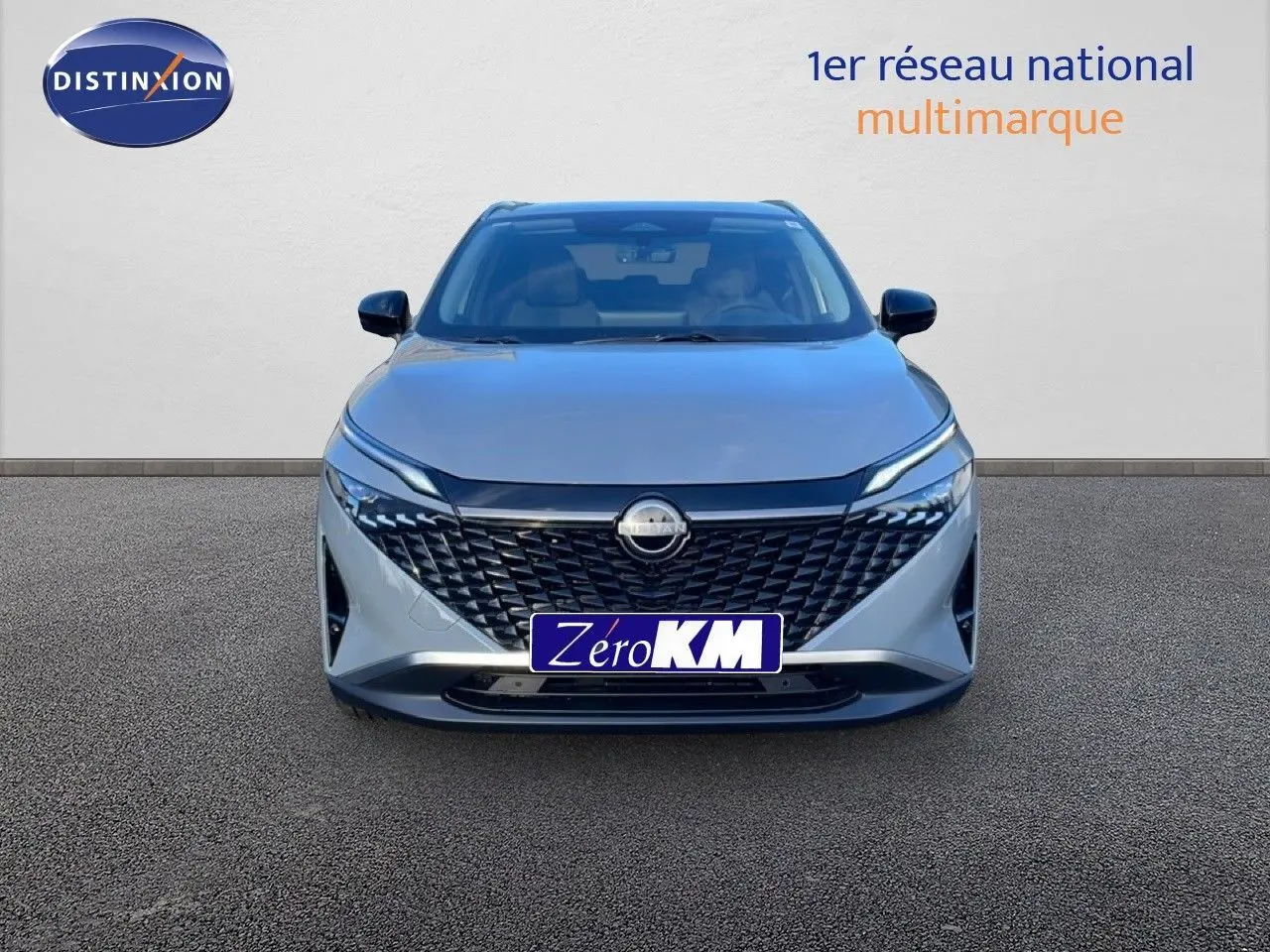 Vue frontale d'un Nissan Qashqai 2025 gris argile métal avec calandre noire et phares LED fins.