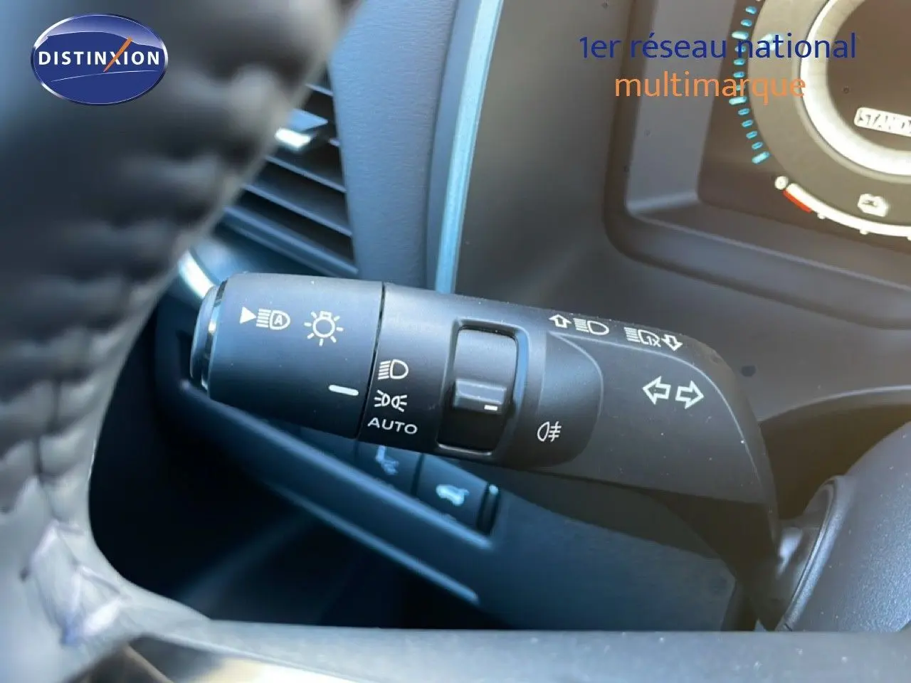 Gros plan sur la commande des feux et clignotants du Nissan Qashqai 1.5 E-POWER gris argile métal, intérieur tableau de bord.