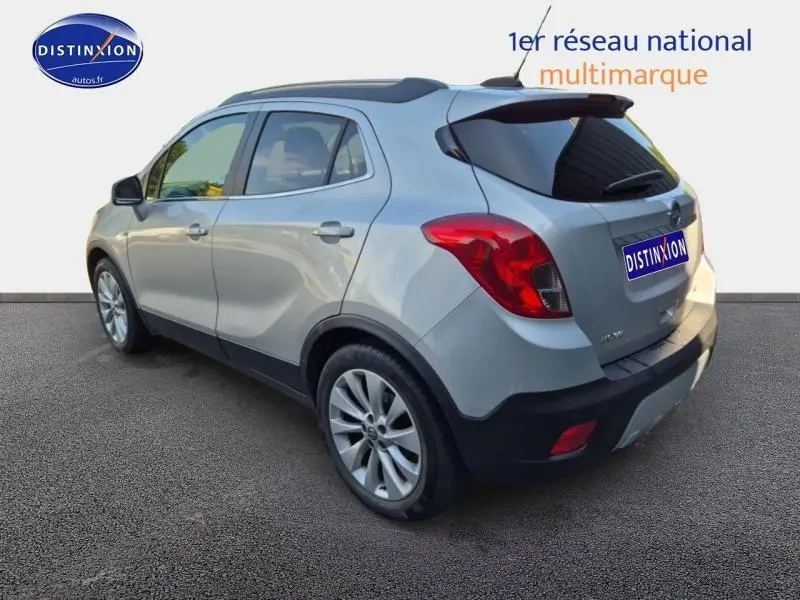 Opel Mokka gris Astéroïde vue 3/4 arrière droit, avec jantes alu et vitres arrière teintées.