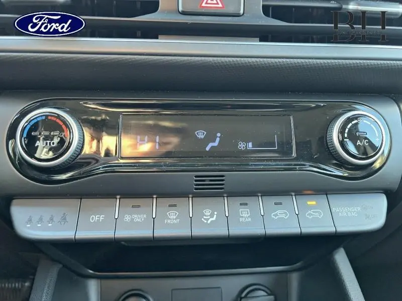 Panneau de commande de climatisation avec écran digital et boutons gris dans l'habitacle d'une Hyundai Kona Dark Knight Métal.