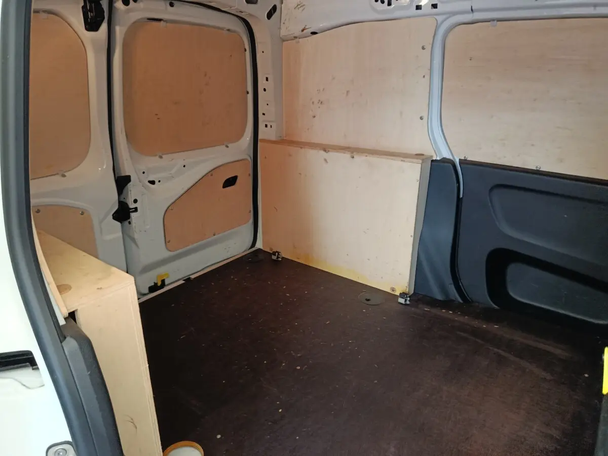 Vue intérieure arrière du coffre blanc du Peugeot Partner 2022, avec cloison et panneaux en bois clair.