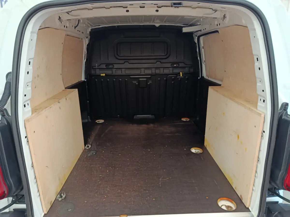 Vue intérieure arrière du coffre blanc du Peugeot Partner 2022 avec cloison pleine et plancher protégé en bois.
