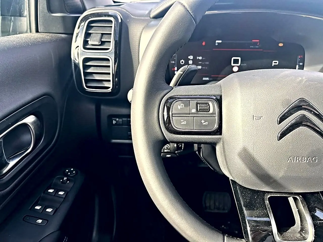 Vue rapprochée du volant noir multifonction et du tableau de bord numérique du Citroën C5 Aircross 2025.