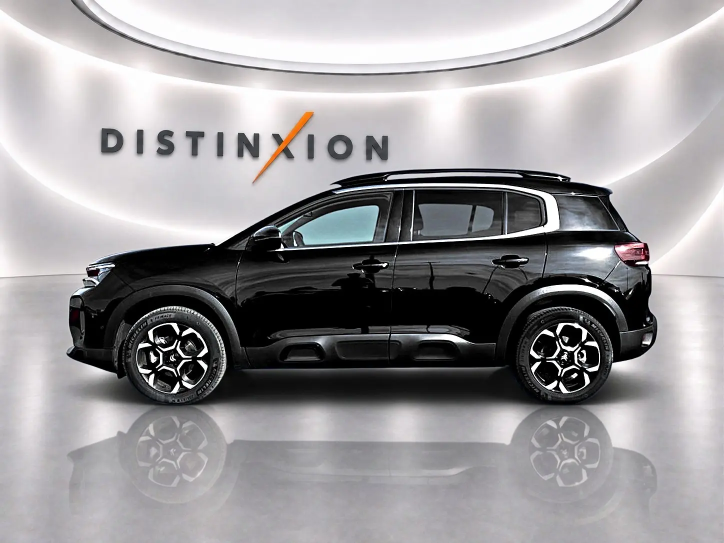 Profil droit du Citroën C5 Aircross noir 2025 avec jantes alu et barres de toit, sur fond blanc lumineux.