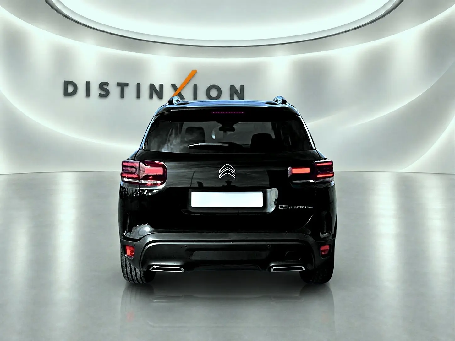 Vue arrière d'un Citroën C5 Aircross noir 2025 dans un showroom avec éclairage moderne et logo Distinxion en arrière-plan.