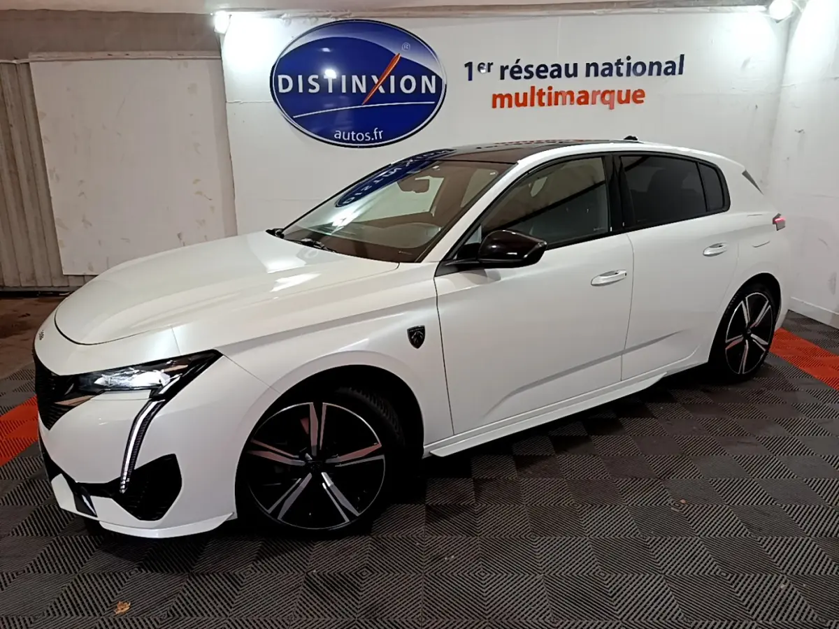 Peugeot 308 PHEV 180 GT blanc vue 3/4 avant droit, avec phares LED et jantes noires distinctives.