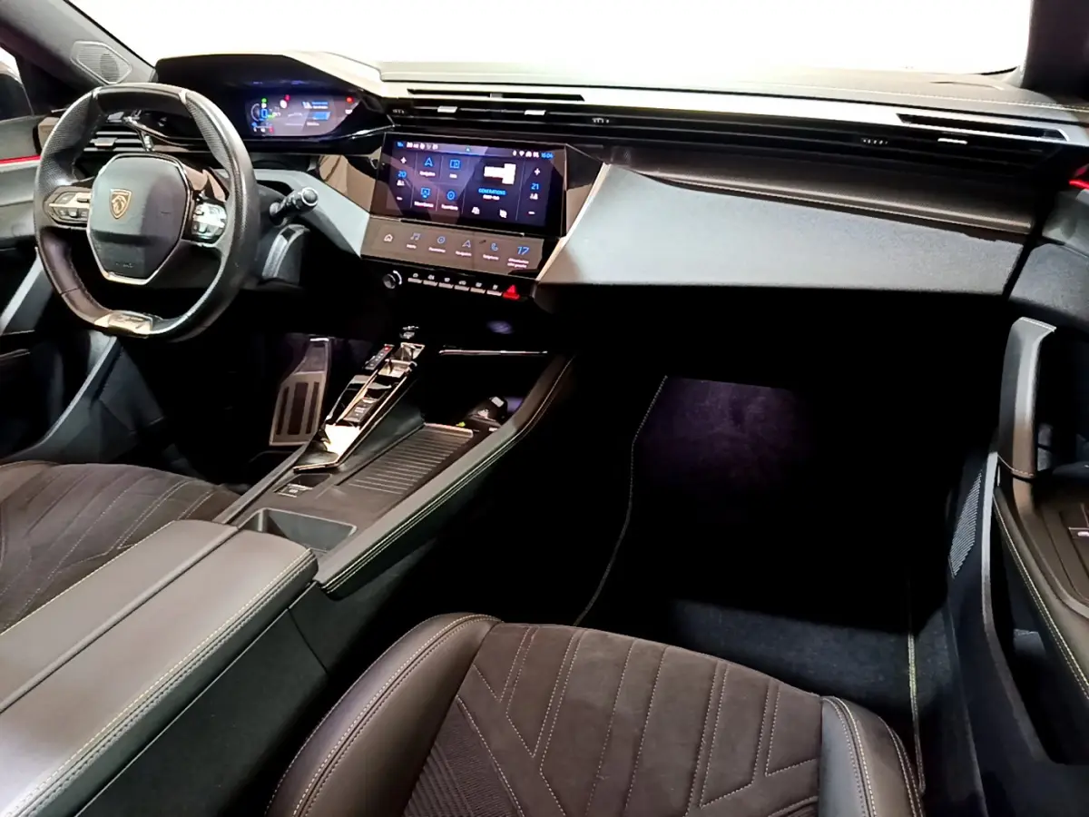 Intérieur Peugeot 308 PHEV 180 GT 2022 vu côté conducteur, tableau de bord moderne avec écran tactile et volant cuir.