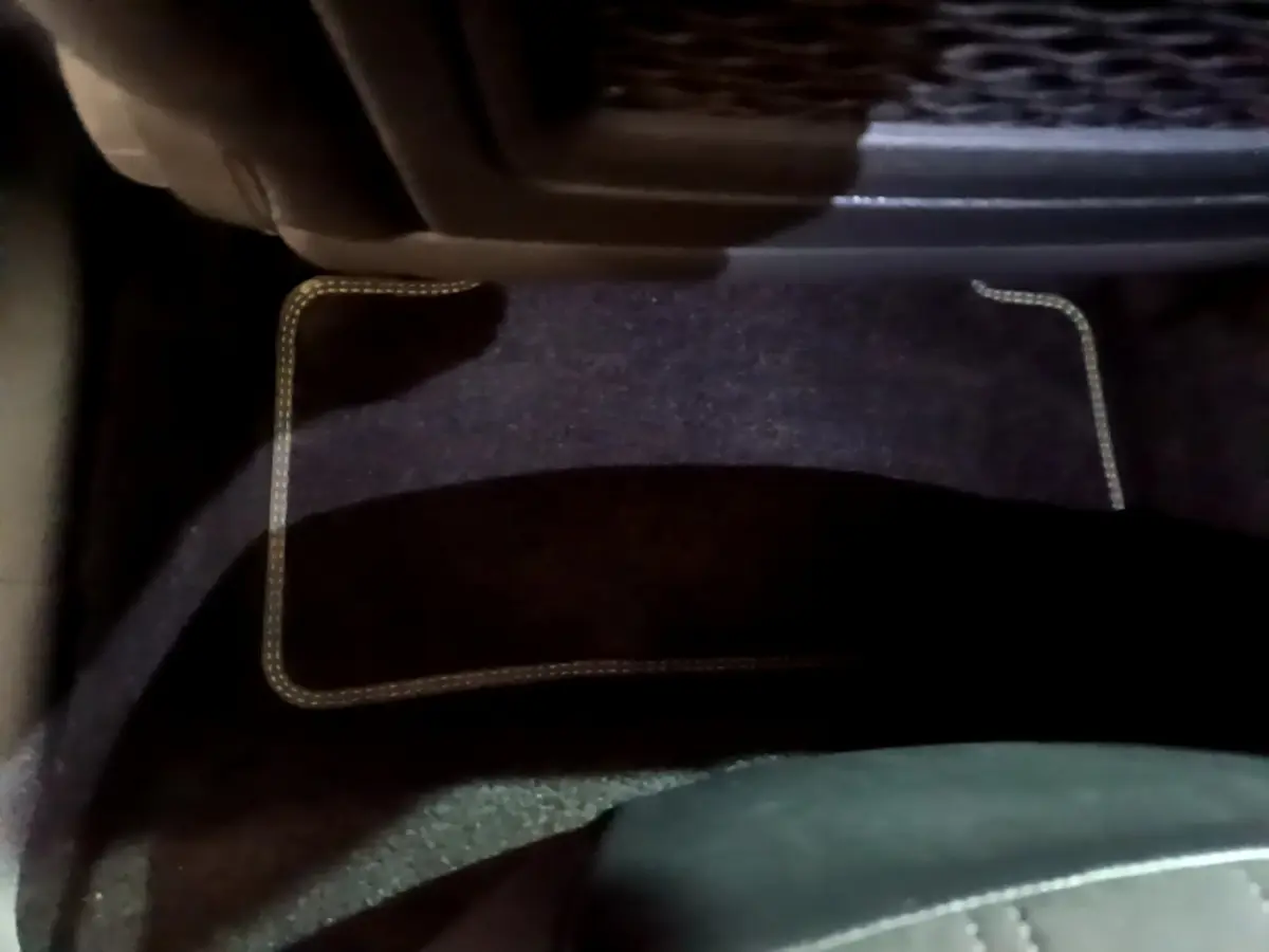 Tapis de sol noir avec surpiqûres claires côté conducteur d'une Peugeot 308 PHEV 180 E-EAT8 GT blanche de 2022.