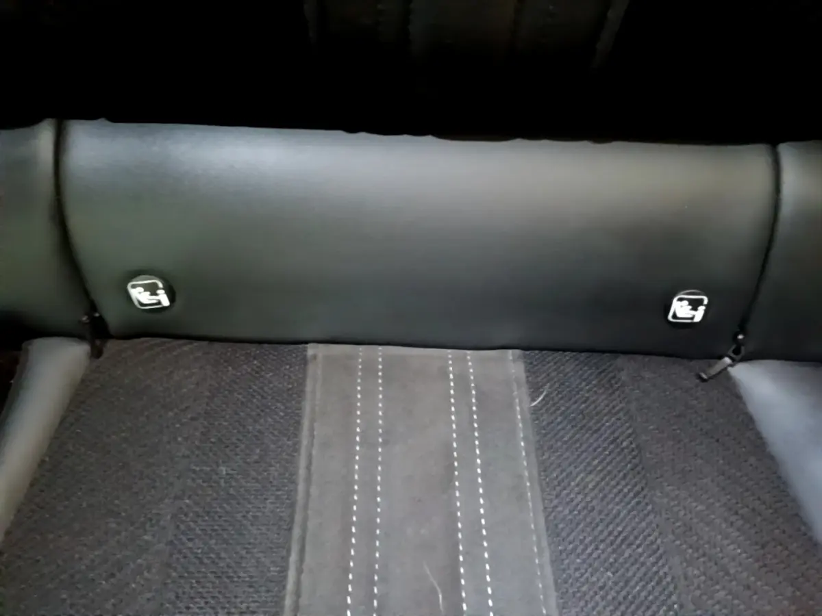 Gros plan sur la banquette arrière noire de la Peugeot 308 PHEV 180 GT avec logos Isofix visibles sur le dossier.