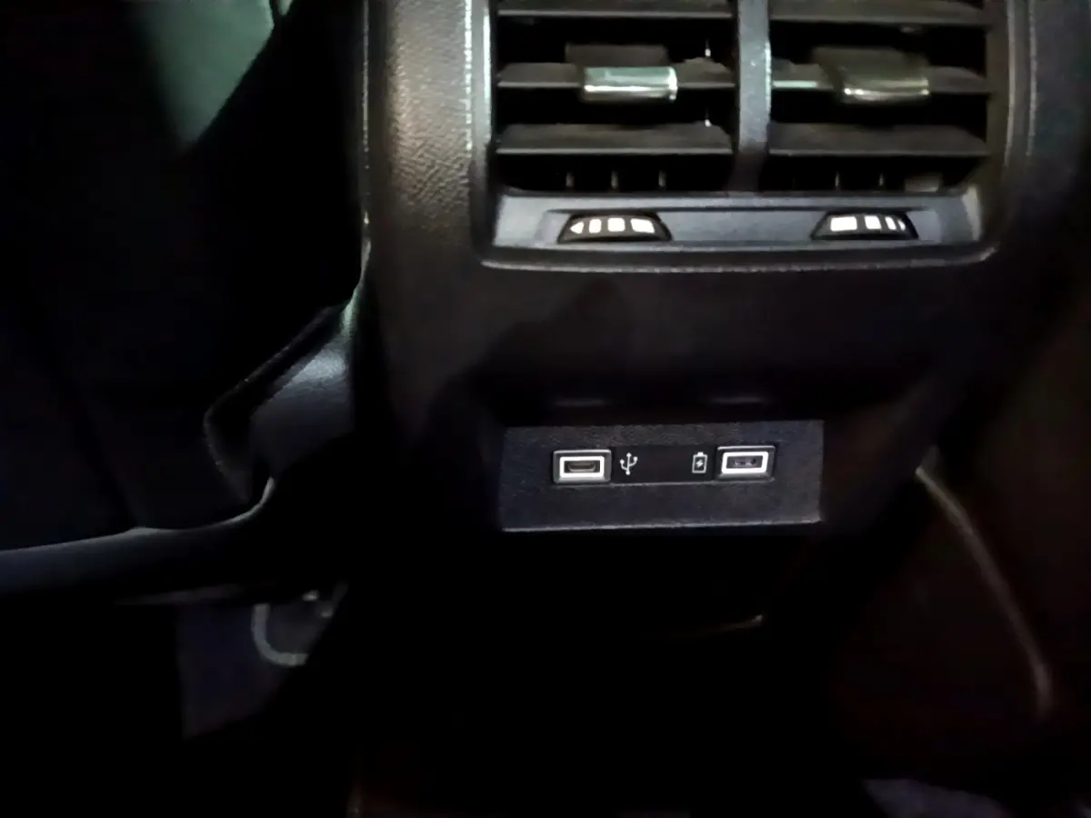 Prise USB double et bouches d’aération arrière noires dans l’habitacle de la Peugeot 308 PHEV GT blanche.