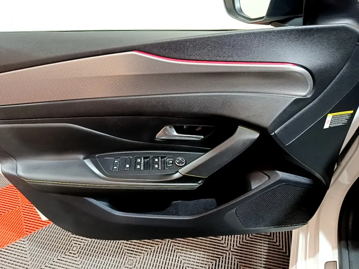 Porte côté gauche de Peugeot 308 PHEV 180 E-EAT8 GT blanche, avec commandes vitres et rétroviseurs intégrées.