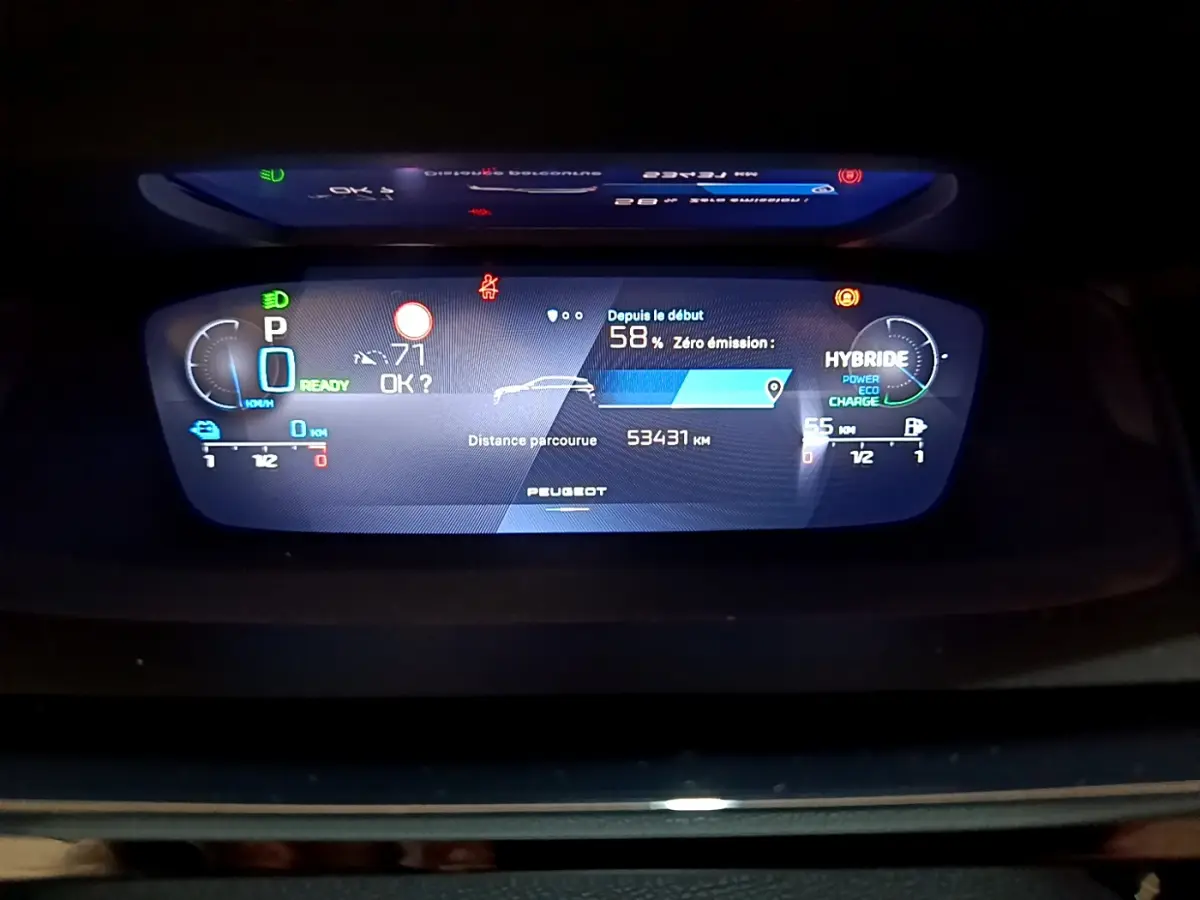 Affichage numérique du tableau de bord de la Peugeot 308 PHEV 180 E-EAT8 GT montrant l'autonomie et mode hybride.