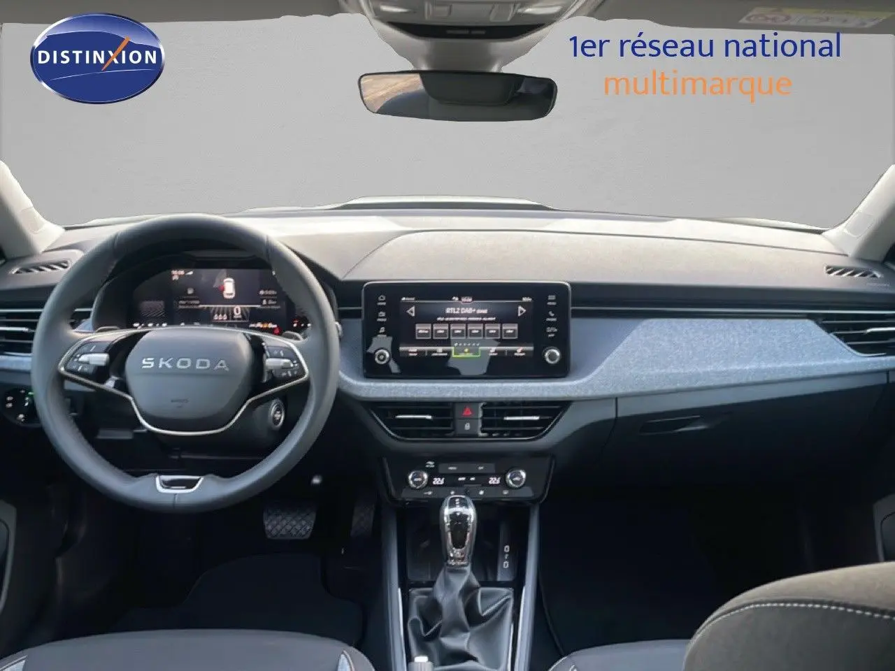Intérieur du Skoda Kamiq 2025 avec tableau de bord gris noir, volant cuir multifonction et écran tactile central.