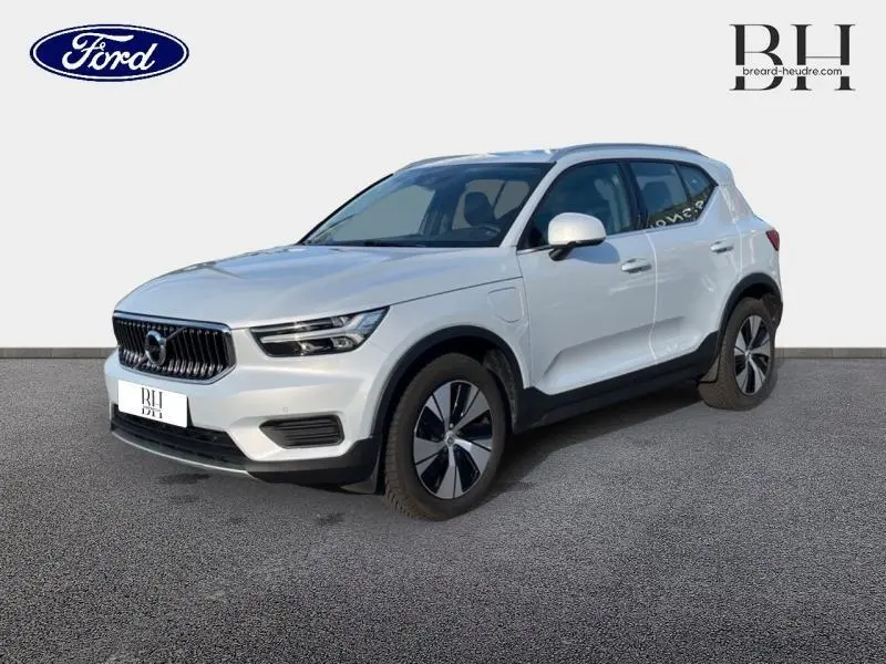 Vue 3/4 avant droite du Volvo XC40 T5 Recharge gris glacier avec jantes alu et calandre chromée sur fond neutre.