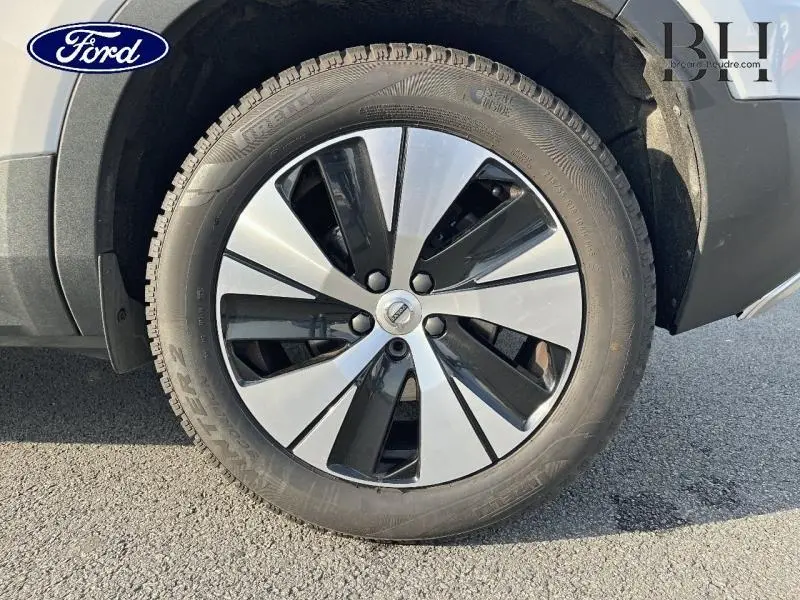 Gros plan sur la jante bicolore noir et argent d’un Volvo XC40 Gris Glacier, avec pneu Pirelli visible.