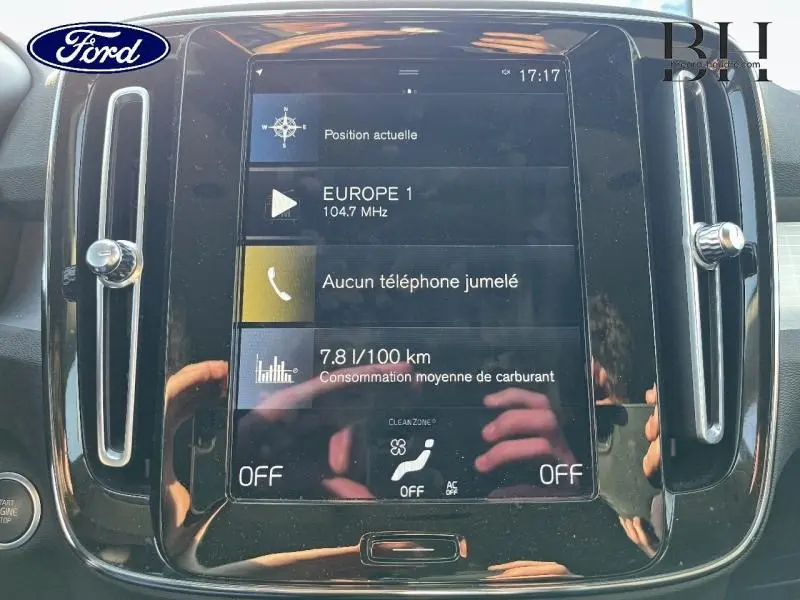 Écran tactile central du tableau de bord d’un Volvo XC40 gris Glacier, affichant la consommation et la radio.