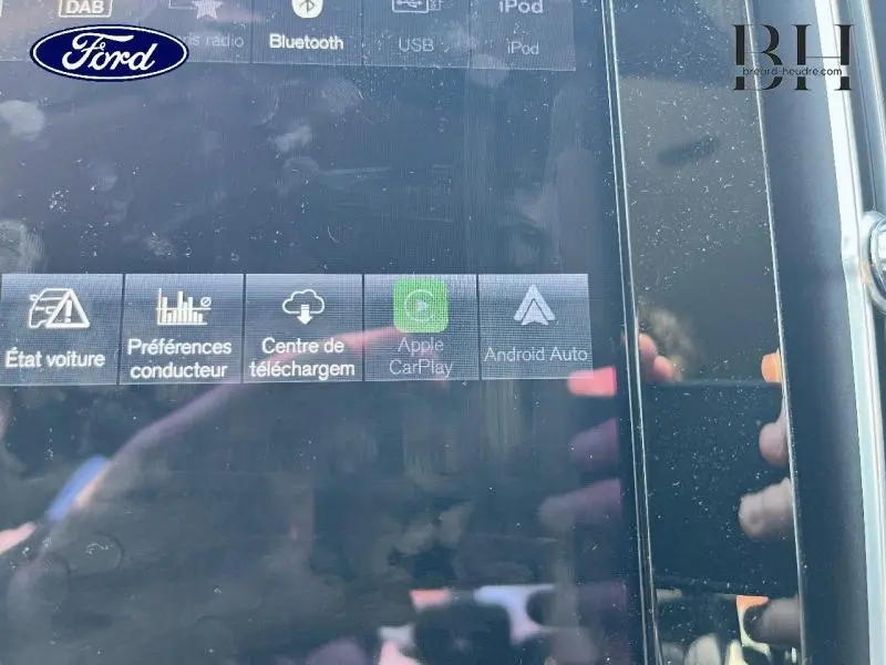 Vue rapprochée de l’écran tactile multimédia du Volvo XC40 gris Glacier, affichant les options Apple CarPlay et Android Auto.