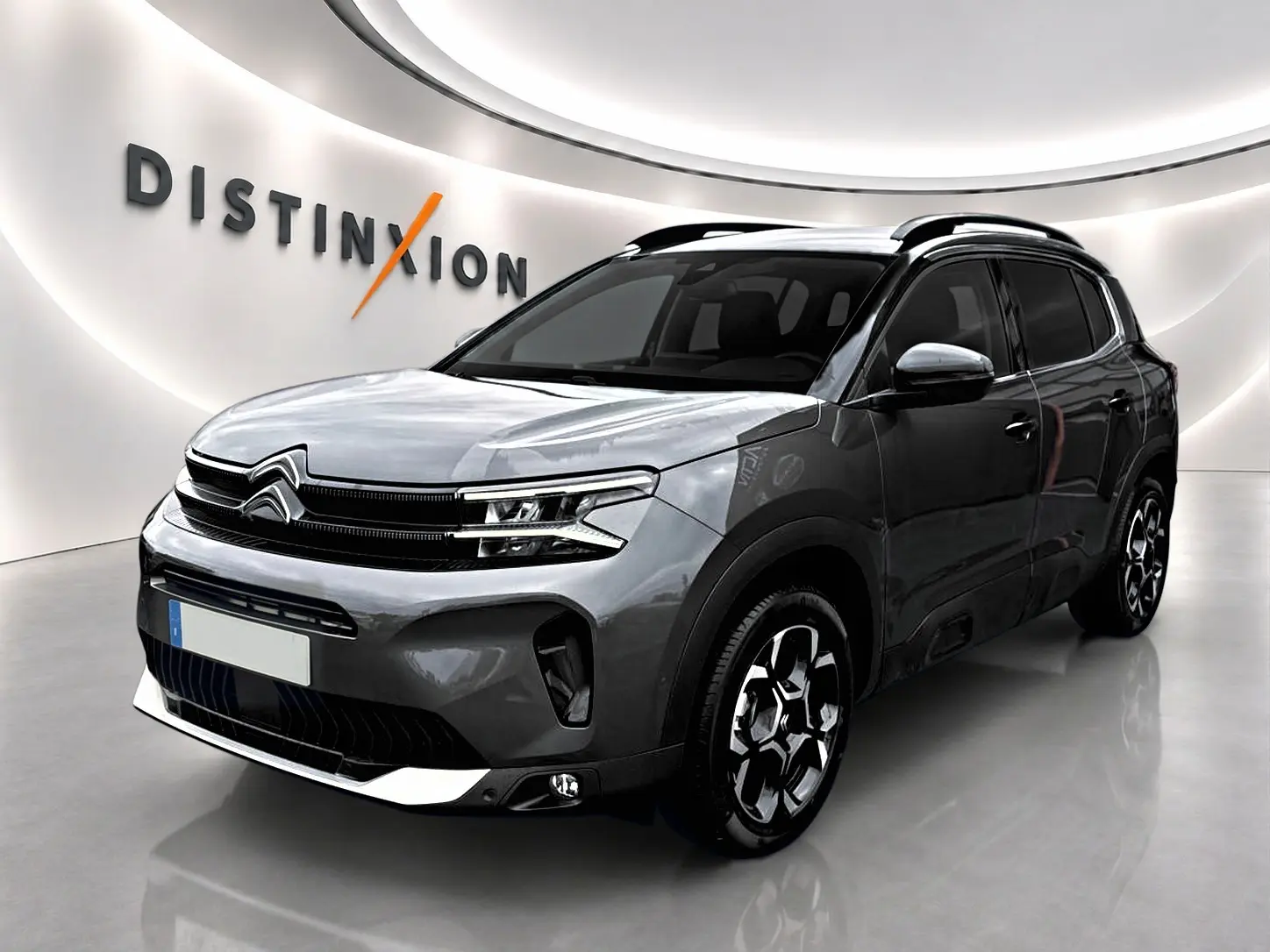 Citroën C5 Aircross gris platinium vue 3/4 avant droit, avec barres de toit et jantes alu distinctives.