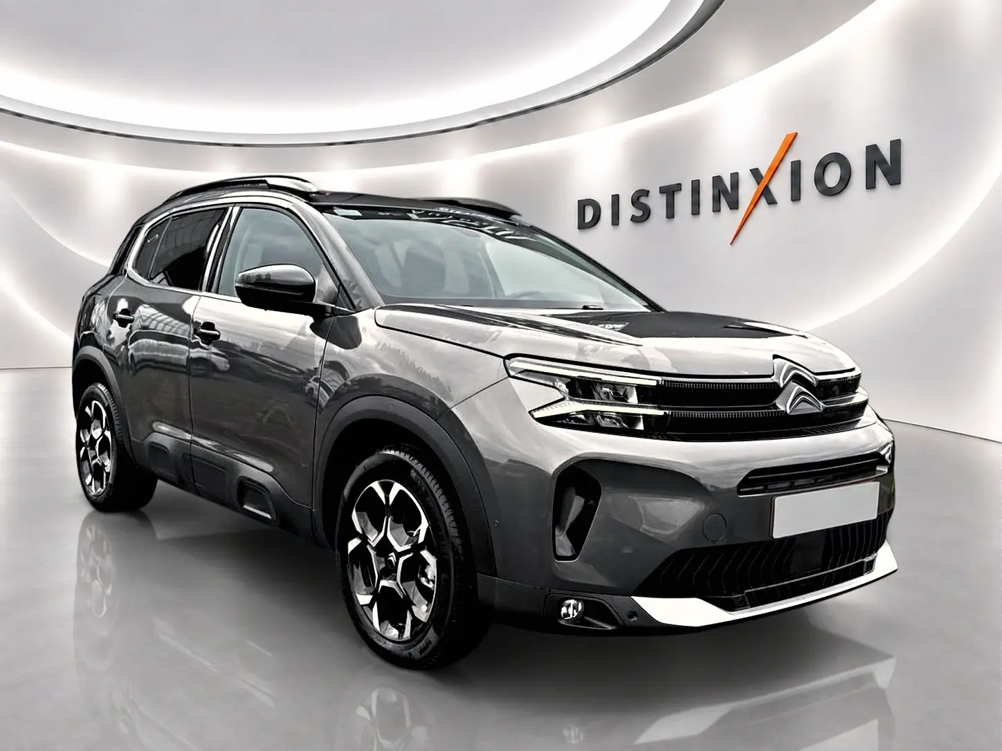 Citroën C5 Aircross gris platinium vue 3/4 avant droit en studio avec jantes alu et barres de toit.