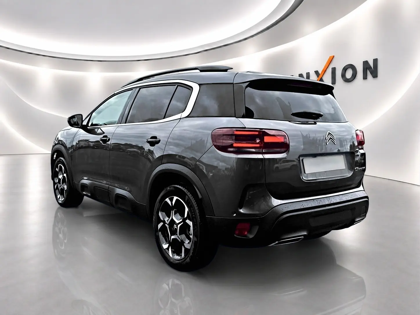 Citroën C5 Aircross gris platinium vue 3/4 arrière droit, avec jantes alu et vitres arrière teintées.