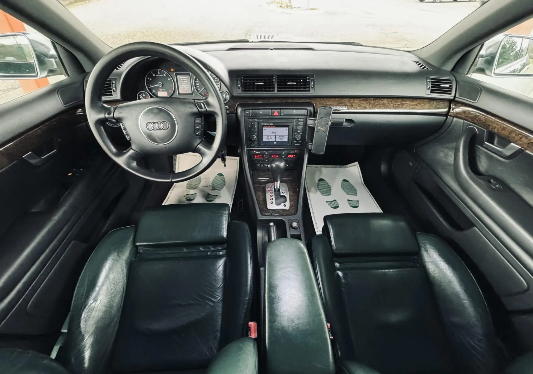 Vue intérieure avant de l'Audi S4 Avant 2004 avec tableau de bord noir et sièges cuir foncé.