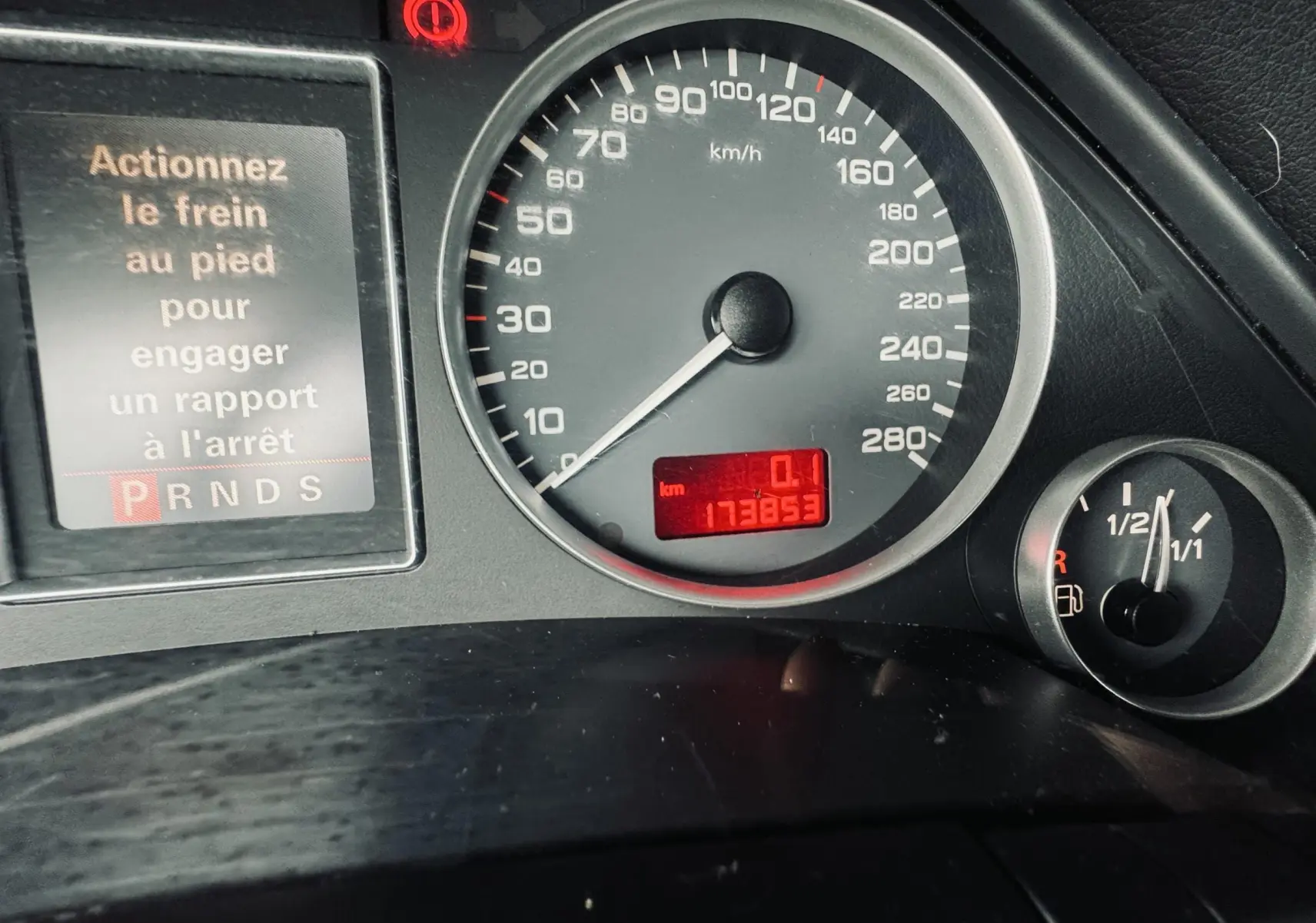Tableau de bord de l'Audi S4 Avant 2004 montrant le compteur à 0 km/h et l'indicateur de carburant à moitié plein.